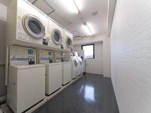 a laundry room with washers and dryers on display at Meitetsu Inn Chita Handa Ekimae in Handa