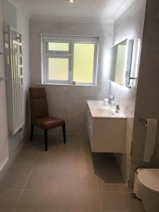 baño con lavabo, silla y ventana en Athgarvan B&B, en Newbridge