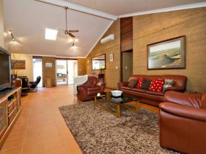 a living room with leather couches and a television at Kingfisher in Margaret River Town