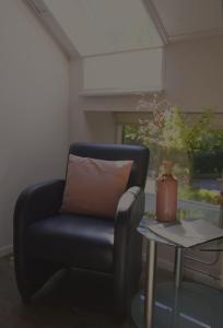 a blue chair sitting next to a table with a vase at Hotel Lemmenhof in Ell +57 photos