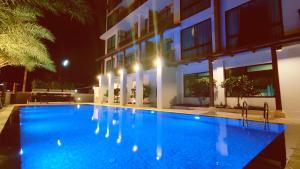 uma piscina em frente a um edifício à noite em Pleasant Chiangmai em Chiang Mai
