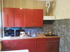 a kitchen with red cabinets and a sink at 12 Pargi in Narva-Jõesuu