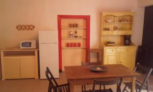 eine Küche mit einem Tisch und einem weißen Kühlschrank in der Unterkunft Le Grenouillet in Le Fleix