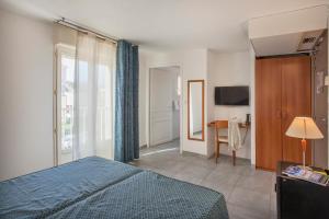 1 dormitorio con cama, mesa y TV en Le Neptune & Spa en Propriano