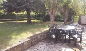 uma mesa e cadeiras num quintal com árvores em Le Grenouillet em Le Fleix