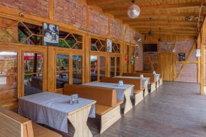 a restaurant with tables and chairs in a building at Pavilon Panzió Étterem és Pizzéria in Gyomaendrőd