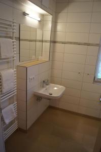 een witte badkamer met een wastafel en een spiegel bij Braumeister Döbler - Ferienwohnungen in Bad Windsheim