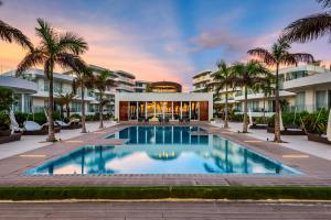 长滩岛Aqua Boracay的一座棕榈树度假村的游泳池,位于一座建筑前