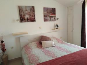sypialnia z łóżkiem i 2 zdjęciami na ścianie w obiekcie Apartments Slavica Jovanovic w miejscowości Sveti Stefan