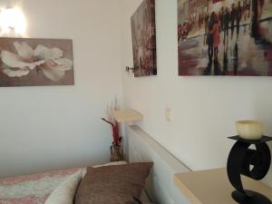 a bedroom with a bed and some pictures on the wall at Apartments Slavica Jovanovic in Sveti Stefan