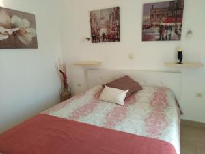 1 dormitorio con 1 cama y algunas fotos en la pared en Apartments Slavica Jovanovic, en Sveti Stefan