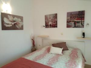 1 dormitorio con 1 cama y algunas fotos en la pared en Apartments Slavica Jovanovic, en Sveti Stefan