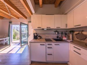 a kitchen with white cabinets and a wooden floor at Ferienhaus Kleine Sommerliebe in Warenshof