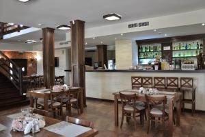 un restaurante con mesas de madera y un bar en Zajazd Sebory, en Romany Sebory