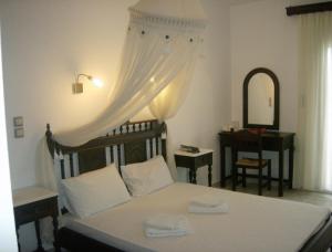a bedroom with a bed with a dresser and a mirror at Evgatis Hotel in Kondiás