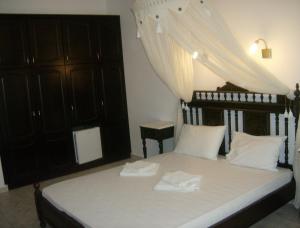 a bedroom with a bed with white sheets and a canopy at Evgatis Hotel in Kondiás