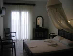 a bedroom with a bed with a dresser and a mirror at Evgatis Hotel in Kondiás