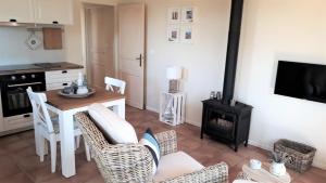 a living room with a table and a stove at Gîte Les Volets Bleus in Monflanquin