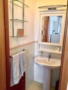 uma casa de banho com lavatório, espelho e toalhas em Casa Mariù em Palermo