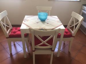uma mesa branca com duas cadeiras e uma tigela azul em Casa Mariù em Palermo