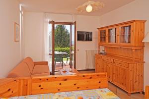 a living room with a bed and a large cabinet at Residence Primera Rompala, GTSGroup in Tignale