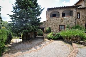 een extern uitzicht op een stenen huis met een poort bij La Casa nel Castello di Gaiche in Piegaro