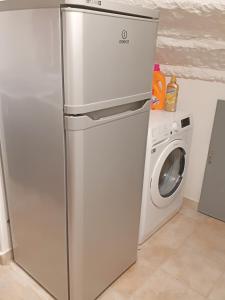 a refrigerator next to a washing machine in a kitchen at San Gimignano Apartments Vernaccia in San Gimignano
