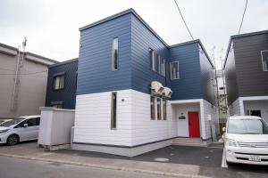 a blue and white house in a parking lot at UCHI Living Stay KCU in Sapporo
