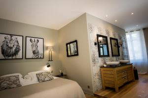 a bedroom with a bed and some pictures on the wall at La Suite d'Elisabeth in Sarlat-la-Canéda