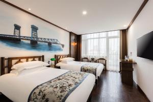 天津Nostalgia Hotel Near Tianjin Polar Ocean Word- Tianjin Fonte Joy World, 10 minutes drive away from Tianjin Tanggu High-Speed Railway Station, Free ice-cream, mineral water, snacks and laundry service, English communication well的有两张床和一台电视的酒店房间 更多37张照片