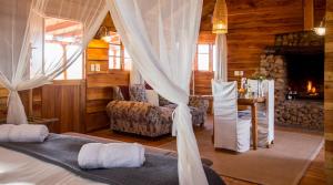 a bedroom with a bed and a living room with a fireplace at Soetdoring Selfsorg in Oudtshoorn