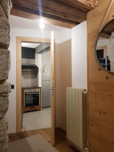 a kitchen with a door open to a kitchen with a radiator at Milla Appartamento 4-6 letti - Pontagna -1km Ponte di Legno T04416 in Villa dʼAllegno