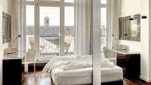 The Pure, Frankfurt, a Member of Design Hotels في فرانكفورت ماين: غرفة نوم بسرير ونافذة كبيرة