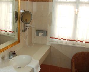 
a bathroom with a sink, mirror, and bathtub at Hotel-Restaurant Kirchenwirt in Weissenkirchen in der Wachau
