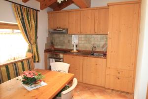 une cuisine avec des placards en bois et une table en bois dans l'établissement Maso Margherita, à Commezzadura