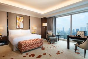 a bedroom with a bed and a desk and a piano at Fairmont Chengdu in Chengdu