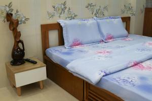 a bed with blue sheets and pink flowers on it at Nature House Homestay in Ho Chi Minh City +25 photos