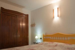 a bedroom with a bed and a wooden cabinet at Casa Relax in Siniscola