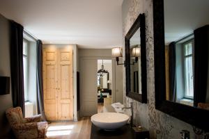 a bathroom with a sink and a mirror on a wall at La Suite d'Elisabeth in Sarlat-la-Canéda