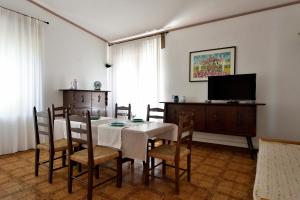 a dining room with a table and chairs and a television at Villa Orrì in Tortolì
