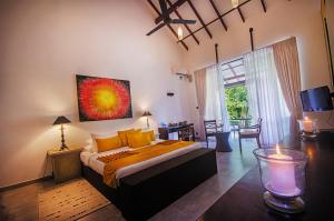 a bedroom with a large bed and a living room at Arika Villa in Dambulla