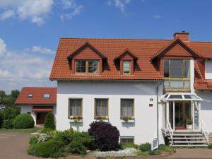 a white house with an orange roof at Hotel Erfurtblick in Erfurt