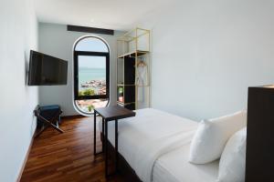 a bedroom with a white bed and a large window at SAVV HOTEL in George Town