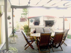 a patio with a table and chairs and a fireplace at Le Vallonee B&B in Aradeo