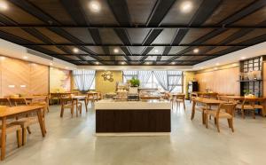 a restaurant with wooden tables and wooden chairs at Nostalgia Hotel Tianjin - Near Polar Ocean World in Tianjin