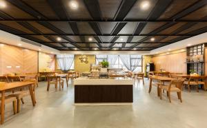 天津Nostalgia Hotel Near Tianjin Polar Ocean Word- Tianjin Fonte Joy World, 10 minutes drive away from Tianjin Tanggu High-Speed Railway Station, Free ice-cream, mineral water, snacks and laundry service, English communication well的有木桌和木椅的餐厅