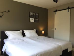 a bedroom with a large white bed with two pillows at Appartement B&B De Koning in Afferden