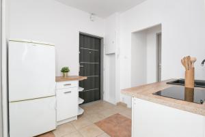 a kitchen with white cabinets and a white refrigerator at Rooms4Less in Gdańsk +14 photos