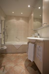 y baño con bañera, lavamanos y bañera. en Engelhard Das Landhotel Garni en Kirchheim am Ries