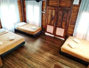 a room with two beds and two chairs in it at Bayu Lestari Island Resort in Mersing